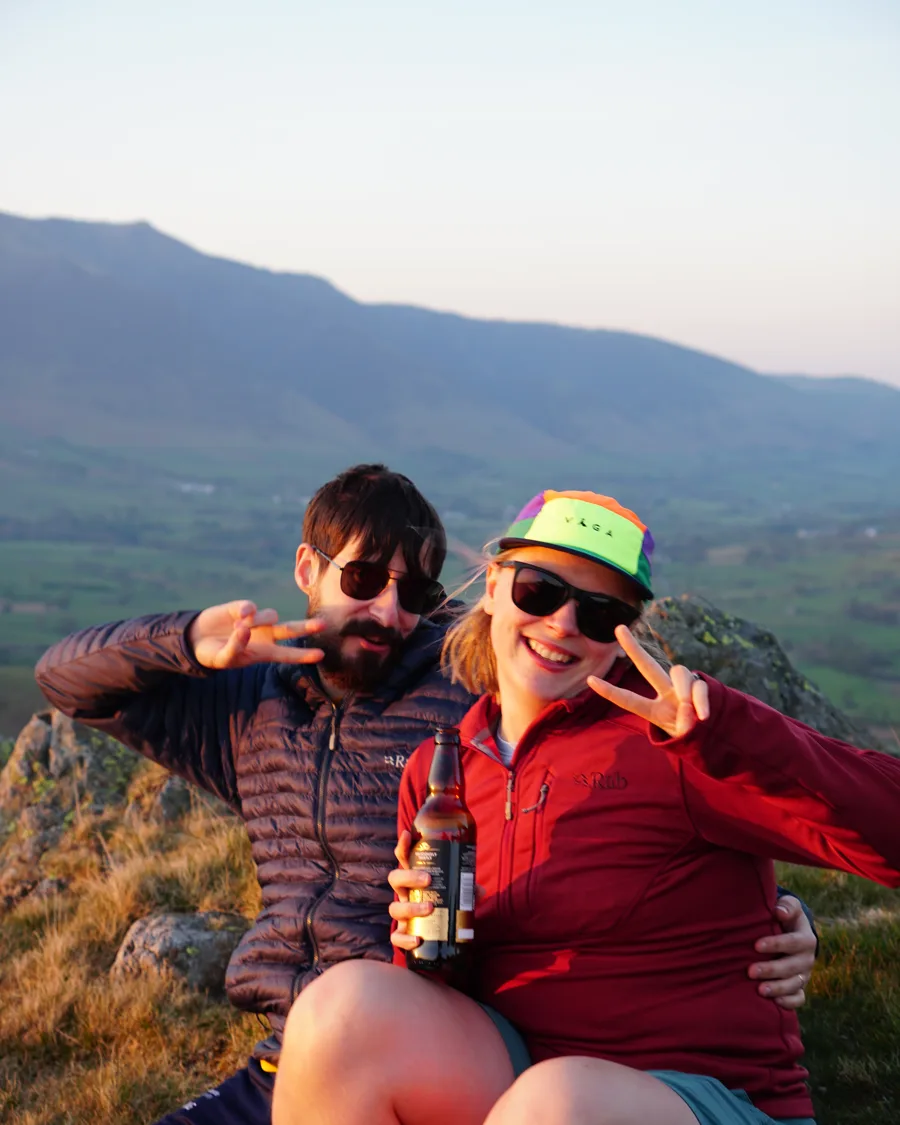 Two hikers celebrating with a toast on a fell top